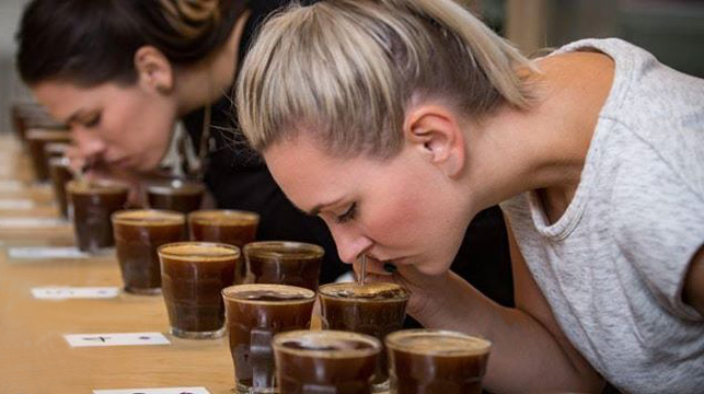 A group of women seated around a table, tasting coffee, embodying a customer-centric approach