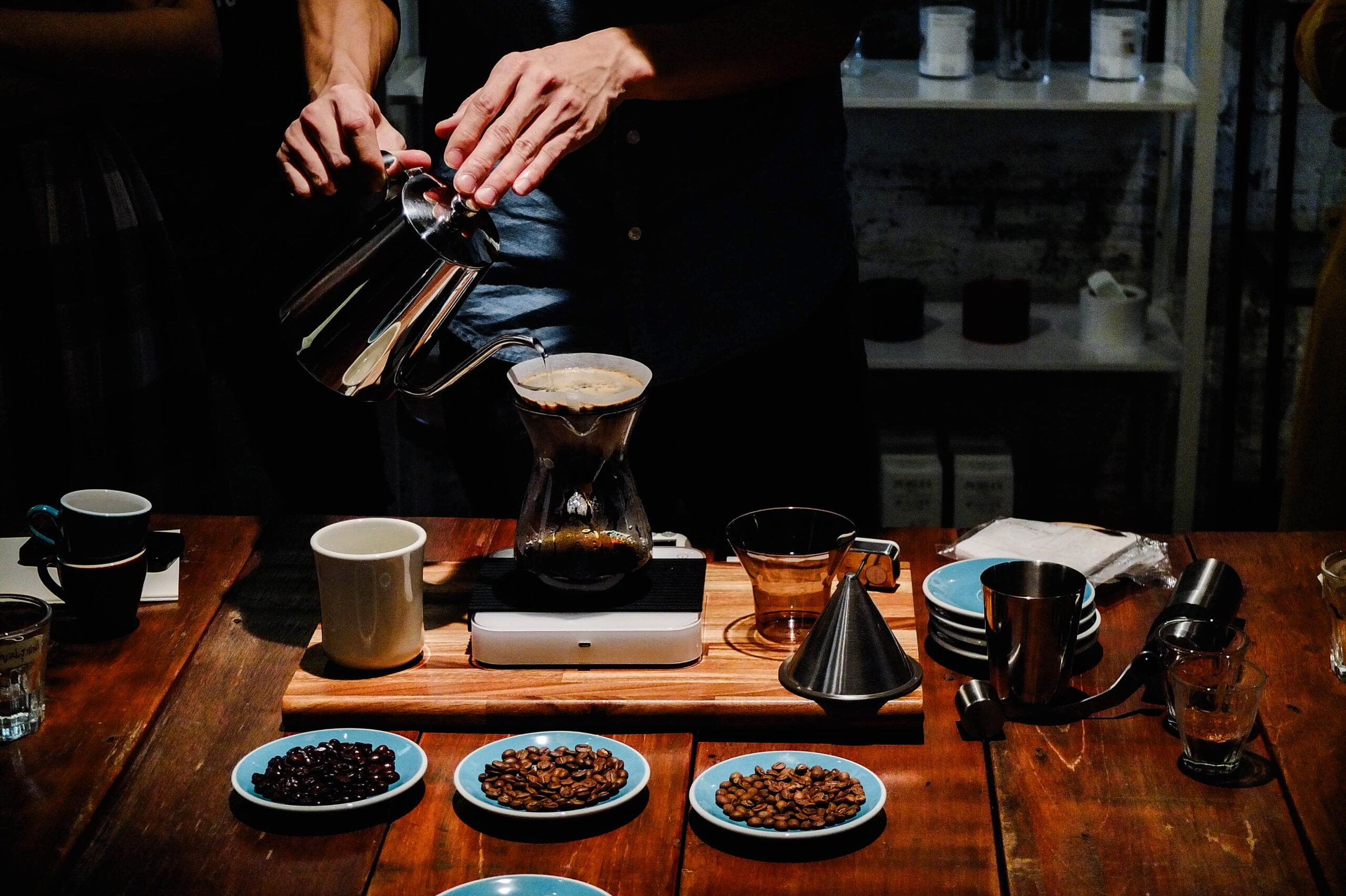 A person meticulously pouring brewed coffee into a glass
